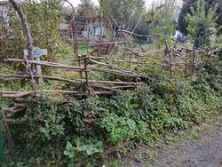 Ein Zaun aus Haselnussstangen und Schnüren.